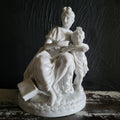 Vintage White Porcelain Figurine Of Woman and Child with Book On Floral Base